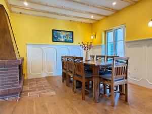 a dining room with yellow walls and a table and chairs at Villa Art Residence Überlingen in Überlingen