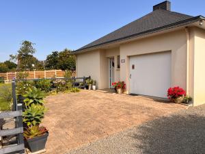 a house with a garage with plants and flowers at L'écrin d'Ar Prajou in Plouénan +4 photos