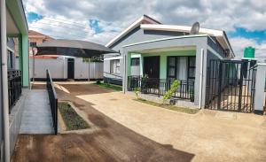 a house with a porch and an umbrella at Area 46 BnB in Lilongwe
