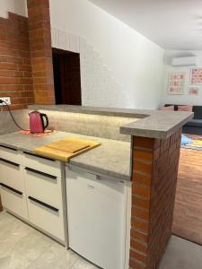 a kitchen with a counter top and a brick wall at Kamińsko 640 - Puszcza Zielonka in Kamińsko +26 photos