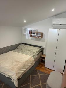 a bedroom with a bed and a white wall at Kamińsko 640 - Puszcza Zielonka in Kamińsko