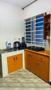 a kitchen with brown cabinets and a sink and a window at Varine House in Dodoma