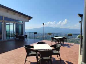 un patio con tavoli e sedie su un balcone di Hotel Dell'Arpa a Viggiano