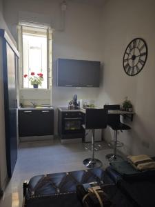 a living room with a couch and a desk and a television at Hypogeum SuiteStudio in Ħal Saflieni