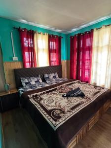 a large bed in a room with red windows at Radhakrishna Homestay in Kulu