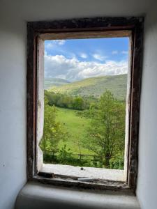 an open window with a view of a green field at Casale dei cappuccini in Scurcola Marsicana