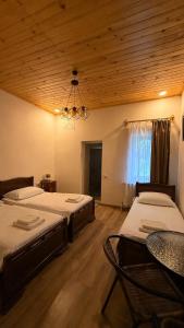 a bedroom with two beds and a table and a chandelier at Mamukas Guesthouse in Mestia