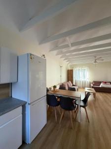 a kitchen and living room with a table and a refrigerator at Pokoje ALbert UL GDAŃSKA 40 in Krynica Morska
