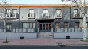 a gray brick building with stairs in front of it at Sercotel Las Estrellas in Ciempozuelos