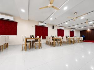a banquet hall with tables and chairs and red curtains at Hotel Big Boss New Digha in Digha +62 photos