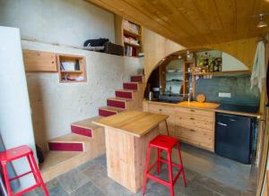 a kitchen with a staircase and a table and red stool at Au Son Du Diois in Die