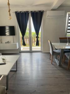 a living room with a large window and a table at Villa Apartments STEFAN - Ramne Ohrid in Ohrid +9 photos