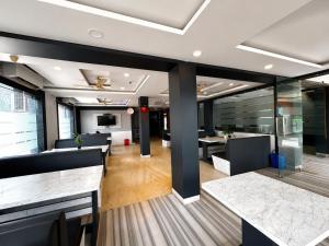 an office with tables and chairs and glass walls at Hotel Big Boss New Digha in Digha