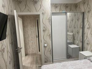 a bedroom with a mirror and a bed in a room at Kvartira in Toshkent-Passajir Bekati