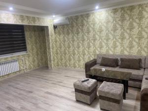a living room with a couch and a table at Kvartira in Toshkent-Passajir Bekati