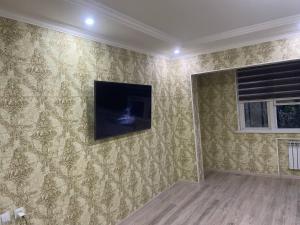 a living room with a television on the wall at Kvartira in Toshkent-Passajir Bekati