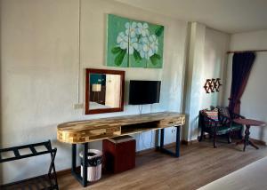 a room with a desk with a television and a mirror at Sugar and Spice Inn in Kata Beach