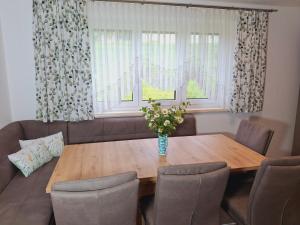 a dining room table with a vase of flowers on it at Sweet Home Alpacas in Timelkam
