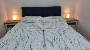 a bed with two towels on it with two lights at Sweet Home Alpacas in Timelkam +2 photos