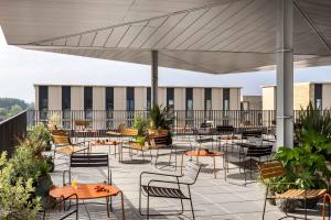 a patio with tables and chairs on a roof at Turing Locke Cambridge in Cambridge