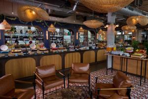 a bar in a restaurant with chairs and a counter at Turing Locke Cambridge in Cambridge