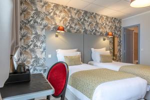 a hotel room with two beds and a red chair at Splendid Hôtel in Paris