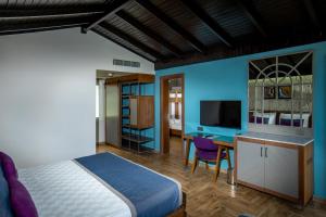 a bedroom with a bed and a desk and a television at Adella Beach Resort Hotel in Kuşadası