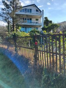 a fence in front of a house with a rainbow at Nice Hotel in Buknari