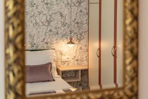 a mirror reflecting a bedroom with a bed and a table at Fontana La Vista in Sitia
