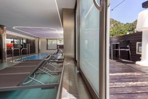 Blick auf ein Schwimmbecken von der Innenseite eines Gebäudes in der Unterkunft Hotel Nexta Escaldes in Andorra la Vella