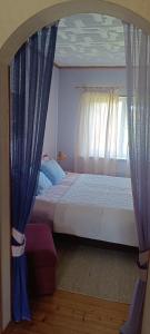 a bedroom with a bed with blue curtains at Kõrgemäe Turismitalu in Tusti