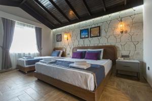 a bedroom with two beds and a stone wall at Adella Beach Resort Hotel in Kuşadası +37 photos