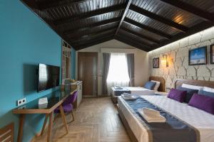 a bedroom with a large bed and a tv at Adella Beach Resort Hotel in Kuşadası