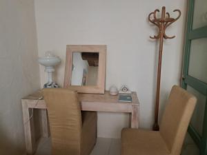 a wooden desk with a mirror and a chair at Au coeur d'Uzès in Uzès +9 photos