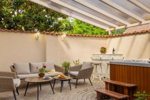 a patio with chairs and tables and a pergola at Chillinn La Maison Cottage Eger in Eger