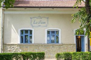 a building with two windows and a sign on it at Chillinn La Maison Cottage Eger in Eger