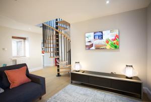 a living room with a couch and a staircase at Glenmoriston Town House Apartments in Inverness