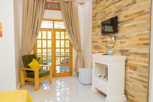 a living room with a fireplace and a tv on a brick wall at MIRAMAR Ruhondo Resort in Muhororo
