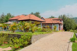 a house with a brick road in front of it at MIRAMAR Ruhondo Resort in Muhororo