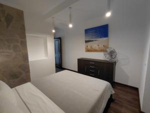 a bedroom with a bed and a fan at Muo sea view Garden in Muo