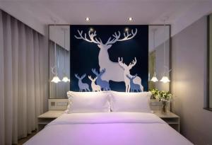 a bedroom with a large bed with deer mural on the wall at Orange Hotel Beijing Shangdi Huandao in Beijing +23 photos
