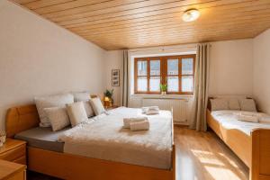 a bedroom with two beds and a wooden ceiling at Alpaka Erlebnis-Ruhige Land-Auszeit in Dinkelsbühl