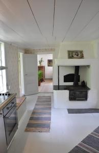 a living room with a fireplace and a kitchen at Grönhagen in Loftahammar