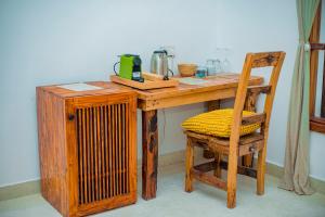 a wooden table with a radiator and a wooden chair at NEST in pongwe in Mdudu Mdogo