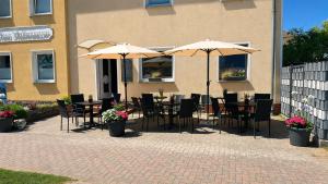 a patio with tables and chairs with umbrellas at Möwennest Zempin in Zempin
