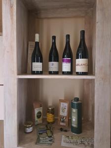 four bottles of wine sitting on a shelf at Au coeur d'Uzès in Uzès