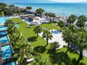 an aerial view of a resort with palm trees and the ocean at Adella Beach Resort Hotel in Kuşadası