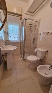 a bathroom with a shower and a toilet and a sink at Maison Etoile de Mer in Agnone Bagni +24 photos