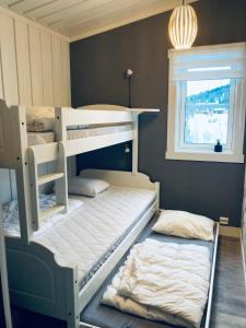 two bunk beds in a room with a window at Flott hytte på Bjørgan in Grong