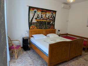 a bedroom with a wooden bed with a painting on the wall at Seaside Villa Katrine in Banjol